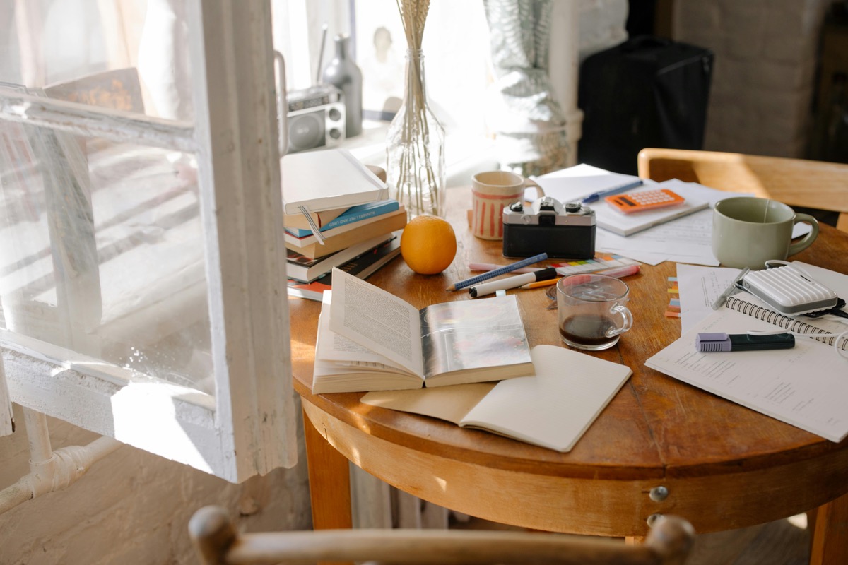 Study table with books, notes, and writing tools for solo Spanish speaking practice